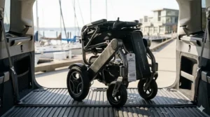 Illustration of the lightweight 300 lb capacity electric wheelchair folded in an SUV trunk with an airline 'GATE CHECKED' tag attached, ready for travel.