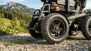 Close-up of deep-tread drive wheels on a power wheelchair designed for outdoor use on grass and dirt.