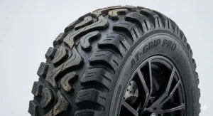 A close-up illustration of deep-tread, pneumatic, AT-GRIP PRO off-road tires on a heavy duty outdoor electric wheelchair.