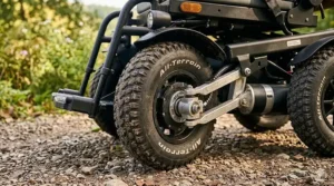 Close-up illustration of deep-tread vacuum tires on an affordable all terrain electric wheelchair for superior grip.