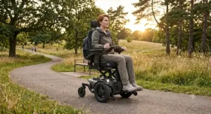 Active individual riding an all-terrain elevating power wheelchair along an outdoor path.
