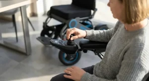 Close-up of a user maneuvering a power wheelchair with a small turning radius using a precision joystick controller