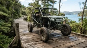 An all-terrain 4-wheel mobility scooter showing its advanced suspension system on a bumpy wooden boardwalk.
